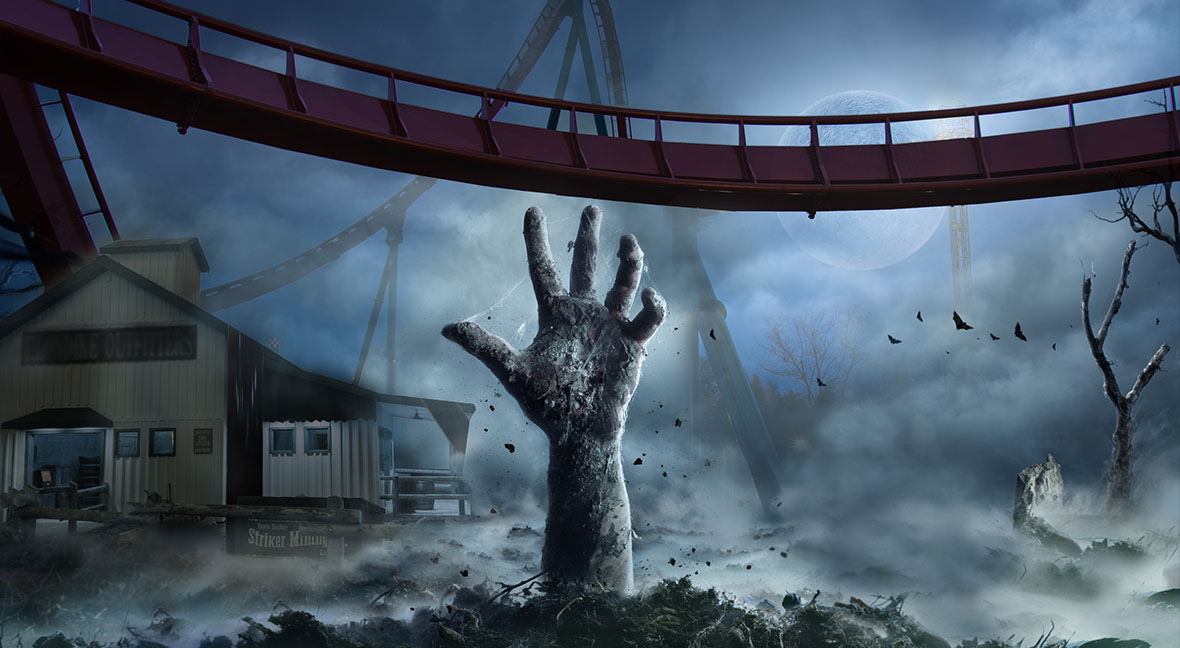 A haunted attraction with a zombie hand reaching up from the grave